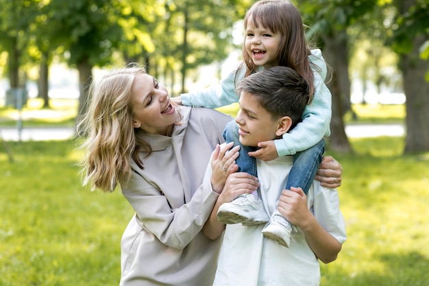 Mother holding and playing with her daughter and son