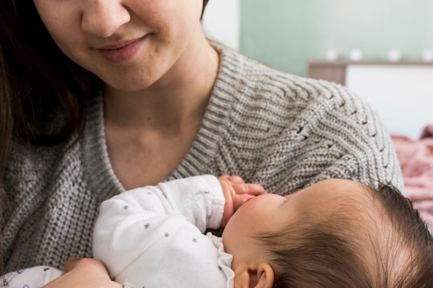 Mother holding sleeping baby in arms 