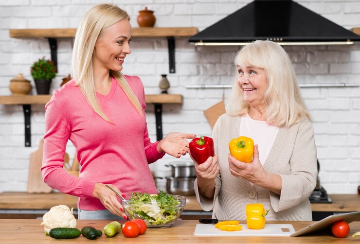 Free Photo mother holding sweet peppers and looking at daughter