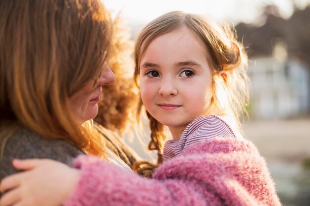 Mother holding young girl close up