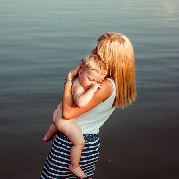 The mother holds hands her son