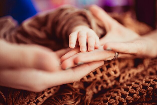 Mother holds on his palm little arm of her child