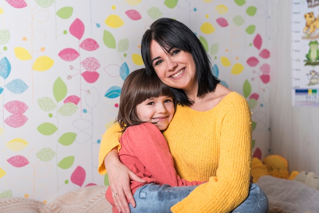 Foto gratuita madre che abbraccia la figlia sul letto