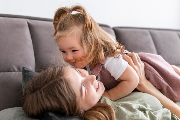 Mother hugging daughter on couch