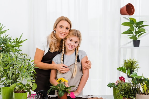 Mother hugging daughter in greenhouse