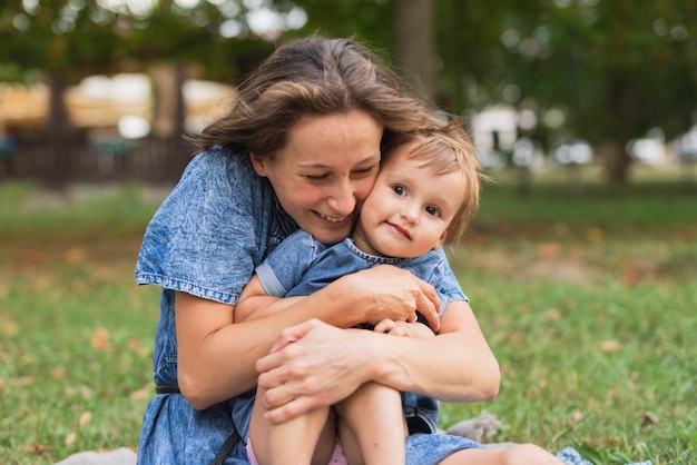 Mother hugging daughter in park