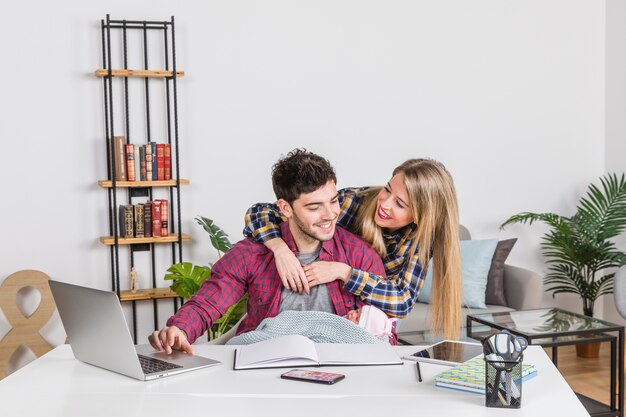 Mother hugging father with baby at desk