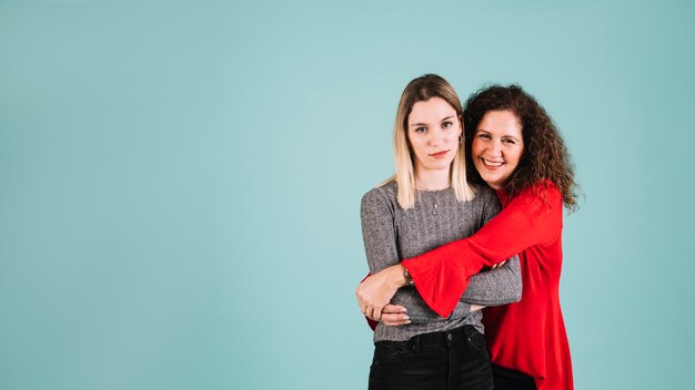 Mother hugging young woman