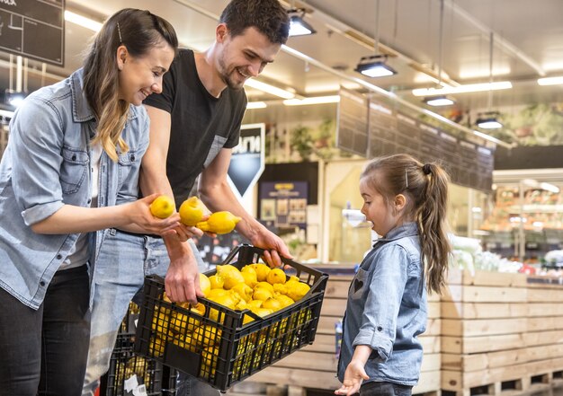 어머니, 남편과 딸이 슈퍼마켓에서 레몬을 선택