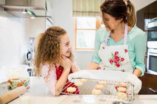 Free photo mother interacting with daughter while holding cookies in coolin