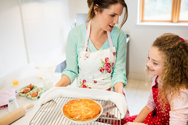 Mother interacting with daughter while holding pancake in coolin