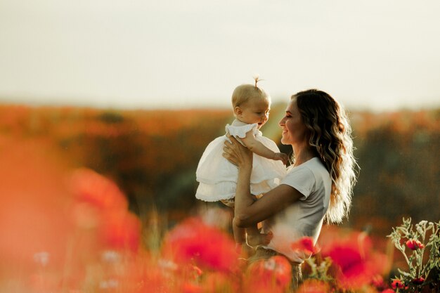 A mother is holding a baby and smiles to her