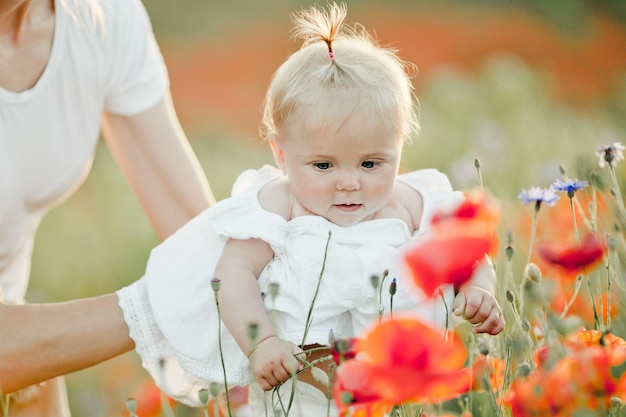 Mother is keeping her baby, a baby looks at flowers