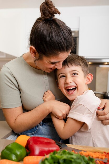 Mother and kid hugging in kitchen