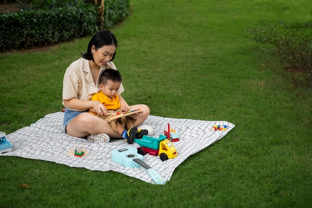 Mother and kid sitting on cloth full shot