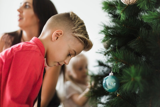 Mother and kids decorating christmas tree