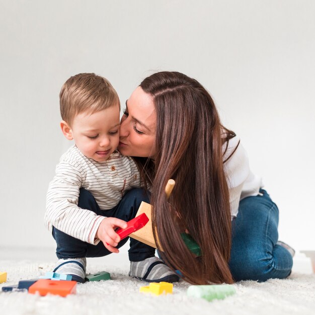 Mother kissing child while playing