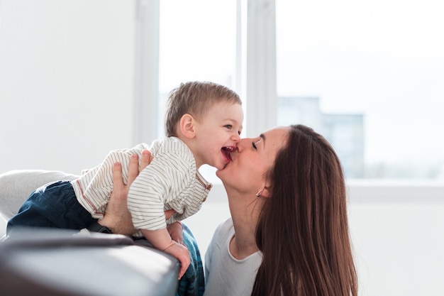 Foto gratuita madre che bacia bambino