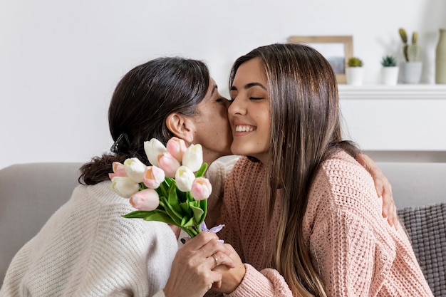 Mother kissing girl for flowers