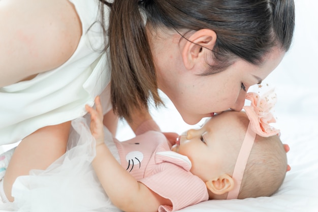 Mother kissing the head of her sleeping baby