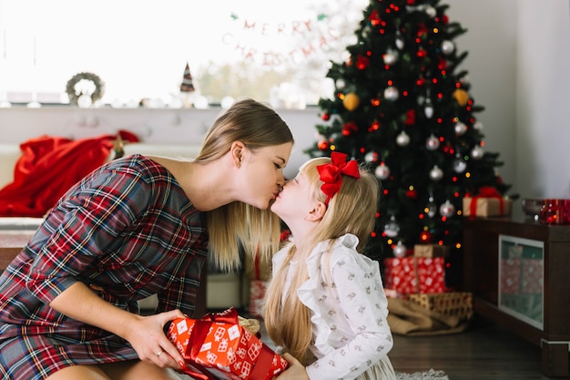 크리스마스에 그녀의 딸을 키스하는 어머니