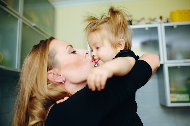 Free photo mother kissing her daughter in the mouth