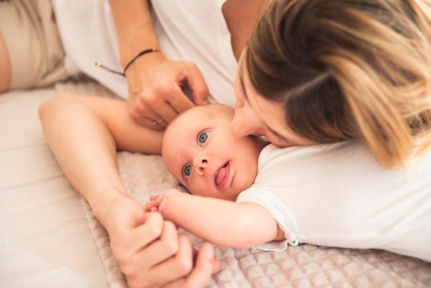 Mother kissing newborn baby close up