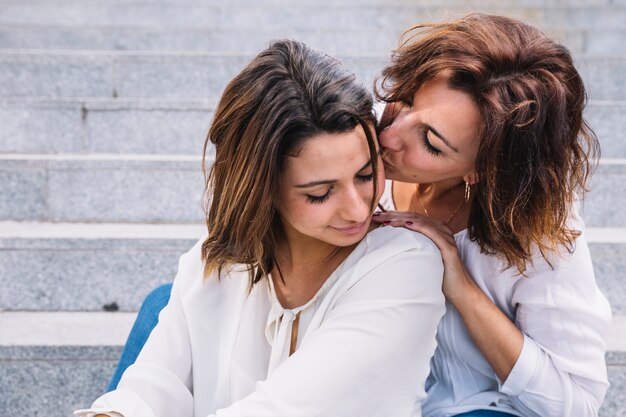 mother kissing woman on steps