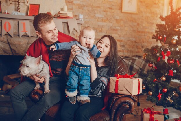 Mother lifting baby up while father holds dog on knees