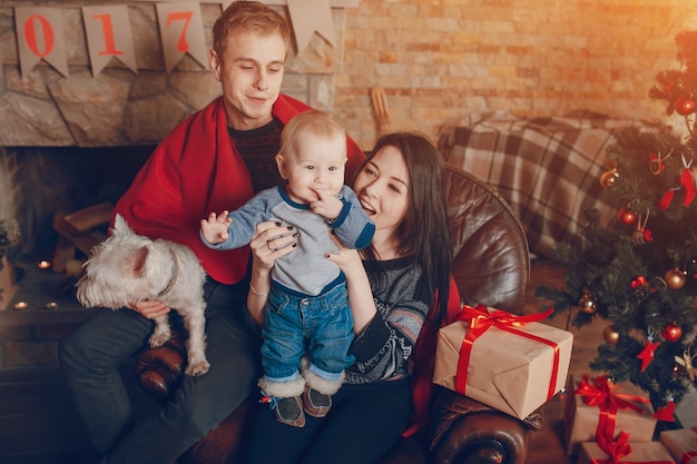 Free photo mother lifting baby up while father holds dog on knees