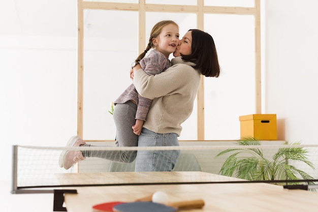 mother lifting cute daughter indoors