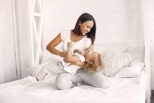 Mother and little daughter have fun at home