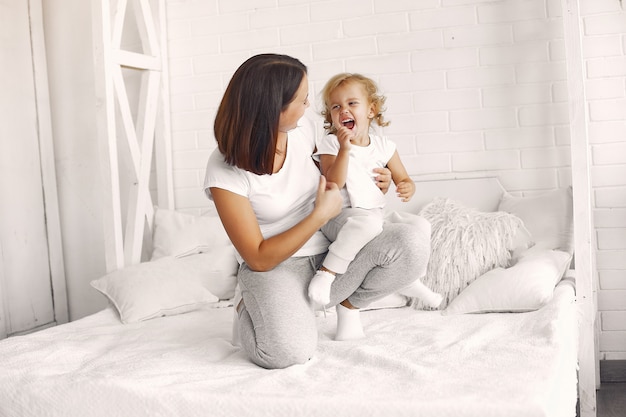 Mother and little daughter have fun at home