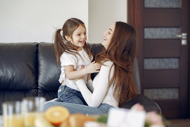 Mother and little daughter have fun at home