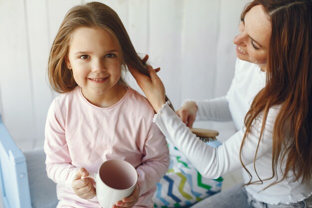 Mother and little daughter have fun at home