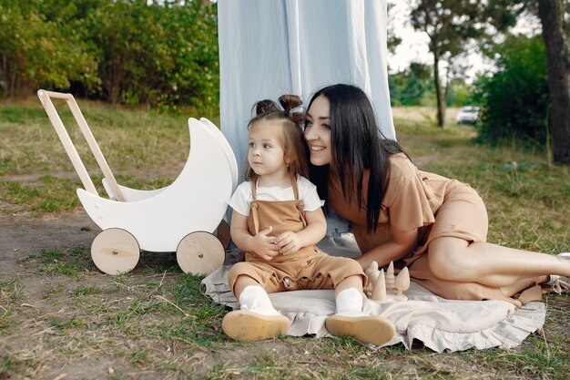 Mother and little daughter playing in a summer field