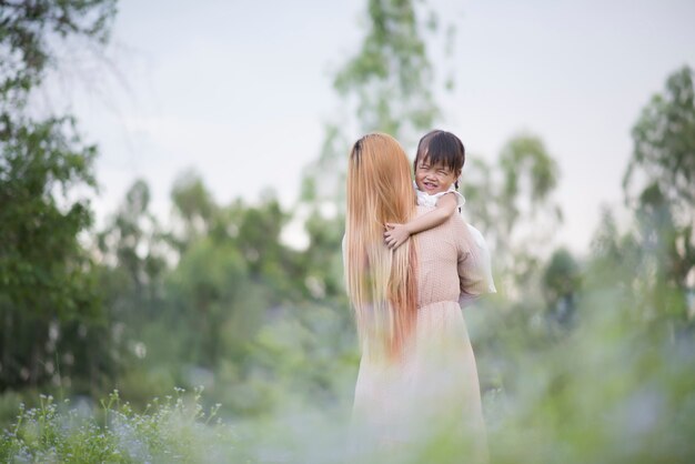 Mother and little daughter playing together in a park