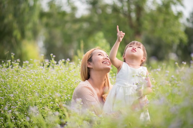 Free photo mother and little daughter playing together in a park