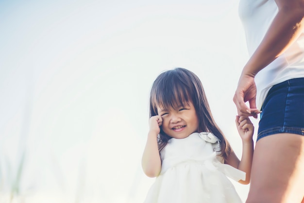 Mother and little daughter playing together in a park