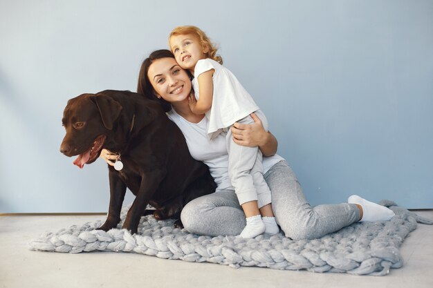 母と娘が自宅で犬と遊ぶ