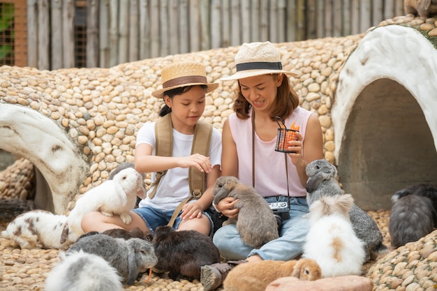 Mother and  Little girl feeding and petting bunny.