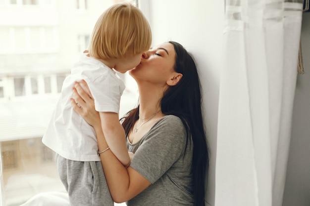 Mother and little son sitting on a windowsill