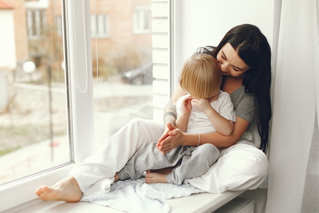 Mother and little son sitting on a windowsill