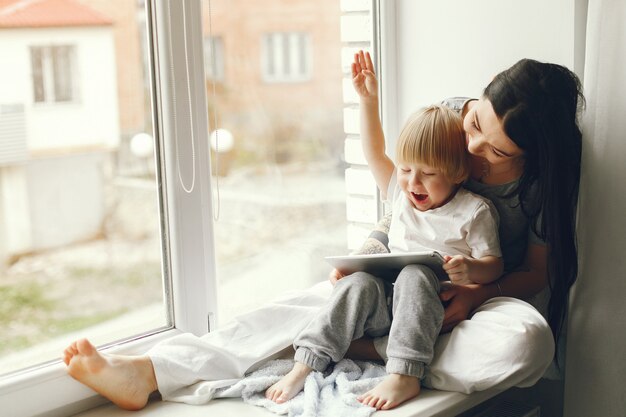Mother and little son sitting on a windowsill