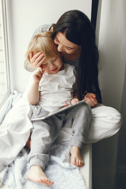 Mother and little son sitting on a windowsill