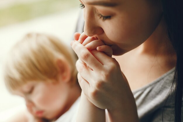 Mother and little son sitting on a windowsill