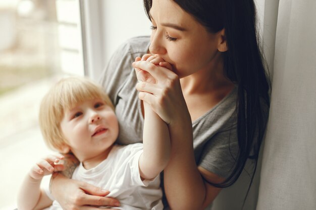 Mother and little son sitting on a windowsill