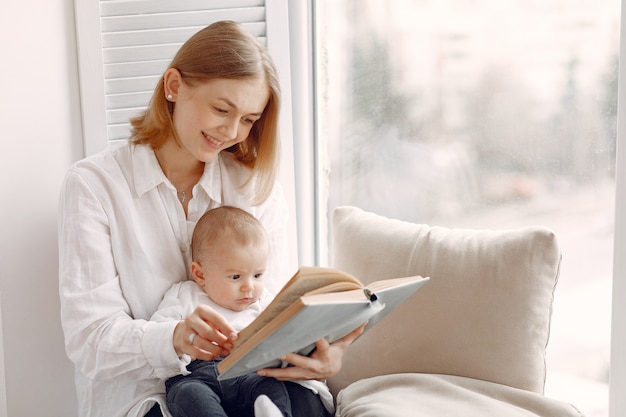 Mother and little son sitting on a windowsill