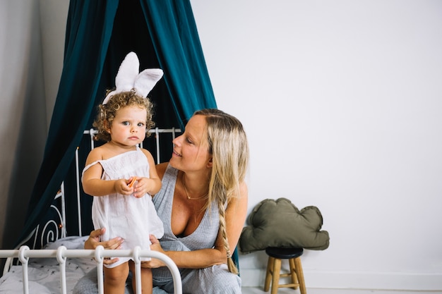 Mother looking at girl with bunny ears