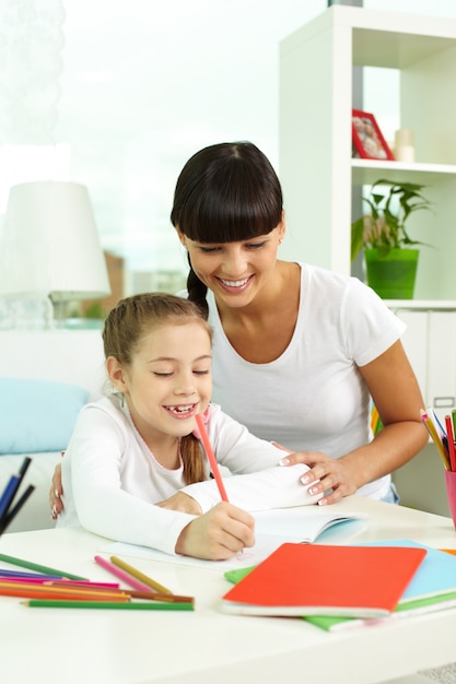 Mother looking at her daughter drawing